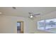 Bright living room featuring a ceiling fan, large window, and arched doorway providing ample natural light and charm at 404 12Th Sw St, Ruskin, FL 33570