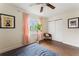 Bright bedroom featuring a ceiling fan, windows with curtains, wood flooring, and artwork at 4600 Chancellor Ne St, St Petersburg, FL 33703