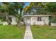 Quaint single-story home with lush landscaping, mature trees, and a welcoming entrance path on a green lawn at 4600 Chancellor Ne St, St Petersburg, FL 33703