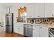 Updated kitchen featuring white cabinets, stainless steel appliances, a farmhouse sink, and a brick backsplash at 4600 Chancellor Ne St, St Petersburg, FL 33703