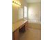 Bathroom with double sinks, vanity, bath tub and wood-look flooring at 4633 Mapletree Loop, Wesley Chapel, FL 33544