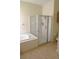 Well-lit bathroom showcasing a tub with shower and glass enclosure, and wood-look flooring at 4633 Mapletree Loop, Wesley Chapel, FL 33544