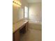 Bright bathroom featuring a double sink vanity, soaking tub, and natural light from a window at 4633 Mapletree Loop, Wesley Chapel, FL 33544