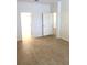 An empty bedroom featuring wood-look tile flooring and a doorway leading to a hallway at 4633 Mapletree Loop, Wesley Chapel, FL 33544