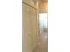 Hallway with wood floors, a bi-fold closet, and an open door leading to a bathroom at 4633 Mapletree Loop, Wesley Chapel, FL 33544