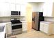 Well-lit kitchen with stainless steel appliances, white cabinets, and hard surface flooring at 4633 Mapletree Loop, Wesley Chapel, FL 33544