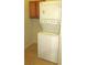 Interior laundry room featuring stackable washer and dryer with shelving at 4633 Mapletree Loop, Wesley Chapel, FL 33544