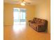 Comfortable living room with hardwood floors, ceiling fan and sliding glass doors to a sunroom at 4633 Mapletree Loop, Wesley Chapel, FL 33544