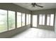 Bright sunroom with tiled flooring, ceiling fan and views of the outdoor living space at 4633 Mapletree Loop, Wesley Chapel, FL 33544
