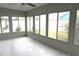 Enclosed sunroom with tile floors and multiple windows offering backyard views at 4633 Mapletree Loop, Wesley Chapel, FL 33544