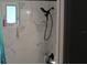 Modern bathroom featuring marble-look tiled walls, a shower head, and a window for natural light at 4928 Lake Ridge Ln, Holiday, FL 34690