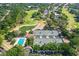An aerial view showcasing the tennis courts, swimming pool, and golf course amidst a lush community setting at 4942 Willow Ridge Ter, Valrico, FL 33596