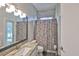 Bright bathroom features granite counters, a decorative shower curtain, and tiled walls at 4942 Willow Ridge Ter, Valrico, FL 33596