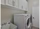 Functional laundry room featuring overhead cabinets and modern washer and dryer units at 4942 Willow Ridge Ter, Valrico, FL 33596