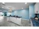 Bright open-concept home features a kitchen island with contrasting blue countertop at 5 Gateshead Dr # 308, Dunedin, FL 34698
