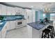 Bright kitchen with white appliances and cabinets, complemented by blue countertops and matching backsplash at 5 Gateshead Dr # 308, Dunedin, FL 34698