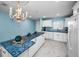 Bright kitchen with white appliances and cabinets, complemented by blue countertops and backsplash at 5 Gateshead Dr # 308, Dunedin, FL 34698