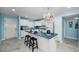 Bright kitchen features white cabinets, a blue accent wall and a large island with a striking countertop at 5 Gateshead Dr # 308, Dunedin, FL 34698