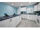 Bright kitchen with white cabinets and blue countertop with appliances and a modern design at 5 Gateshead Dr # 308, Dunedin, FL 34698