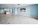 Open concept space with kitchen and living room with blue accent walls and modern flooring at 5 Gateshead Dr # 308, Dunedin, FL 34698