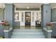 Close up of front porch with seating and potted plants flanking the black paneled door at 516 14Th Ne Ave, St Petersburg, FL 33701