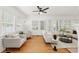 Sunlit living area featuring hardwood floors, white walls, and plenty of natural light from large windows at 516 14Th Ne Ave, St Petersburg, FL 33701