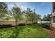 Well-kept backyard featuring green grass, mature trees, and a privacy fence at 5225 5Th N Way, St Petersburg, FL 33703