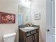 Stylish half bathroom featuring granite countertop, modern vanity, and decorative artwork at 5225 5Th N Way, St Petersburg, FL 33703