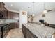 Modern kitchen with an island, granite countertops, stainless steel appliances, and dark wood cabinets at 5225 5Th N Way, St Petersburg, FL 33703