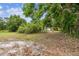 View of the lot featuring grassy areas, trees, and a glimpse of the property at 5232 72Nd N Way, St Petersburg, FL 33709