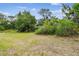 Wide shot of the property showing the lot and surroundings with grassy and sandy features at 5232 72Nd N Way, St Petersburg, FL 33709