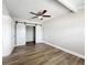 Bedroom features modern flooring, barn-style closet doors, neutral paint and a ceiling fan at 6269 50Th N Ave, St Petersburg, FL 33709