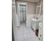 Bathroom featuring tile flooring, white vanity, and a shower with decorative accent tile at 6906 Shady Pl, Tampa, FL 33634
