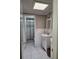 Bathroom showcasing a tiled shower and a vanity with storage at 6906 Shady Pl, Tampa, FL 33634