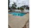 Backyard view of a swimming pool with a concrete deck and tropical plants in a fenced-in area at 6906 Shady Pl, Tampa, FL 33634