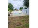 Backyard featuring a swimming pool, patio area, landscaping, and a white fence for privacy at 6906 Shady Pl, Tampa, FL 33634