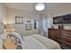 Comfortable bedroom with decorative pillows, a dresser, and a window with plantation shutters at 7406 Parkshore Dr, Apollo Beach, FL 33572