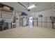Organized garage space with ample storage cabinets, shelving, and epoxy-coated floor, and refrigerator at 7406 Parkshore Dr, Apollo Beach, FL 33572
