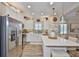 Modern kitchen with a center island, stainless steel appliances, and white cabinetry, open to the living area at 7406 Parkshore Dr, Apollo Beach, FL 33572
