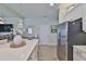 Kitchen island with stainless steel refrigerator and view to living room at 7406 Parkshore Dr, Apollo Beach, FL 33572