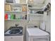 Functional laundry room equipped with modern washer and dryer, shelving, and storage solutions at 7406 Parkshore Dr, Apollo Beach, FL 33572