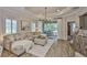 Bright living room featuring a comfortable sectional sofa, tray ceiling, and sliding glass doors to the outdoor space at 7406 Parkshore Dr, Apollo Beach, FL 33572