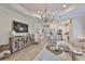 Spacious living room with a kitchen view, a decorative cabinet, and a large-screen television at 7406 Parkshore Dr, Apollo Beach, FL 33572