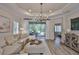 Bright living room featuring a comfortable sectional sofa, tray ceiling, and sliding glass doors to the outdoor space at 7406 Parkshore Dr, Apollo Beach, FL 33572