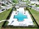 An aerial view shows the geometric design of the pool, surrounded by patio and lounge chairs at 7554 Wallflower Trl, Wesley Chapel, FL 33545
