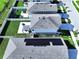 Aerial view of neighborhood featuring home with solar panels, fenced backyard, and other amenities at 7554 Wallflower Trl, Wesley Chapel, FL 33545