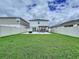 Wide view of the backyard, featuring a well-maintained lawn and a patio with a charming pergola at 7554 Wallflower Trl, Wesley Chapel, FL 33545