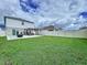 Beautiful backyard with a large green lawn, a concrete patio, a dark pergola, and seating at 7554 Wallflower Trl, Wesley Chapel, FL 33545