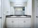 Bathroom featuring double sink vanity with modern fixtures, a large mirror, and hard surface floors at 7554 Wallflower Trl, Wesley Chapel, FL 33545