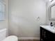 Modern half bathroom featuring a dark vanity, framed mirror, and stylish fixtures at 7554 Wallflower Trl, Wesley Chapel, FL 33545